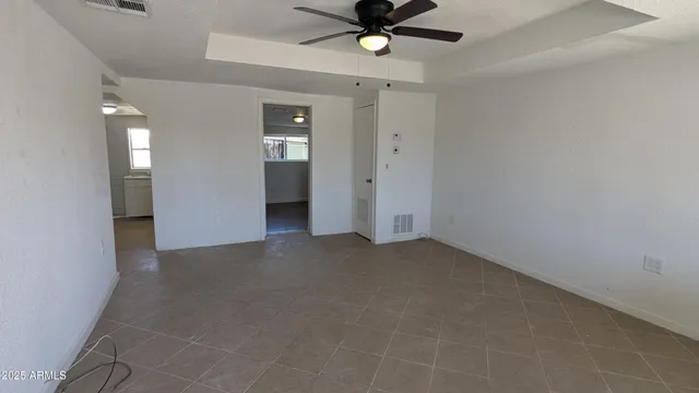 an empty room with closet and a chandelier fan