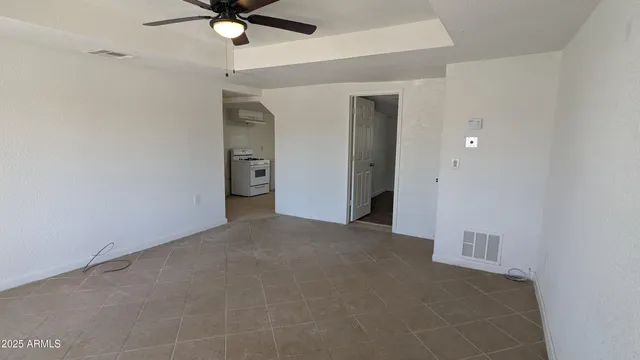 a view of an empty room and a ceiling fan