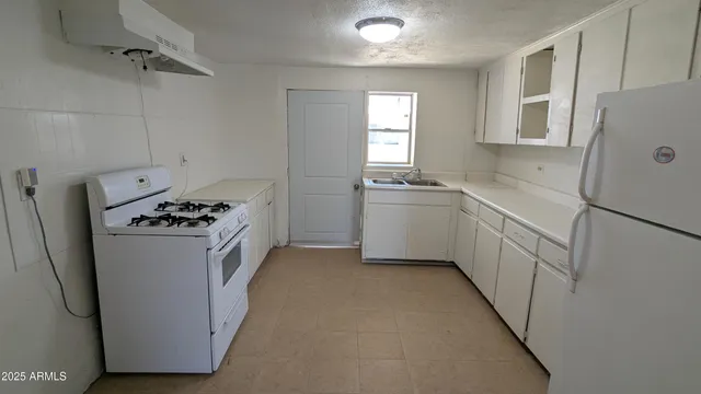 a kitchen with white cabinets and white appliances