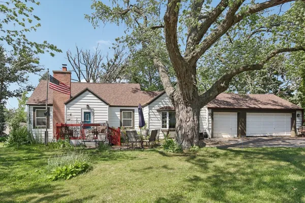 a front view of a house with a garden and trees