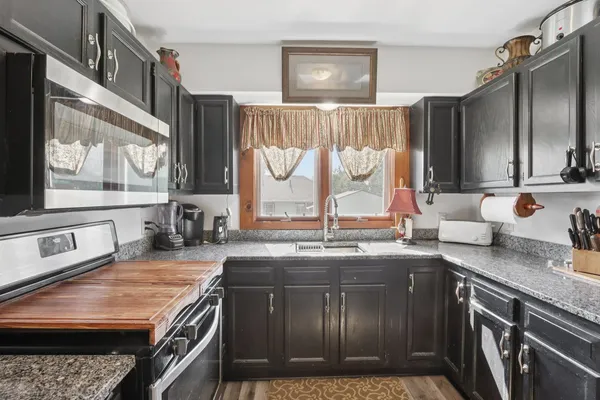 a kitchen with stainless steel appliances granite countertop a stove and a microwave