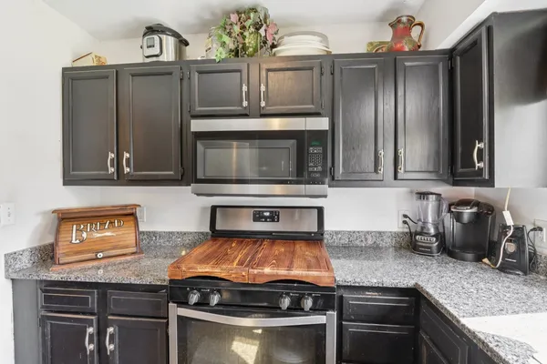 a kitchen with stainless steel appliances granite countertop a refrigerator and a sink