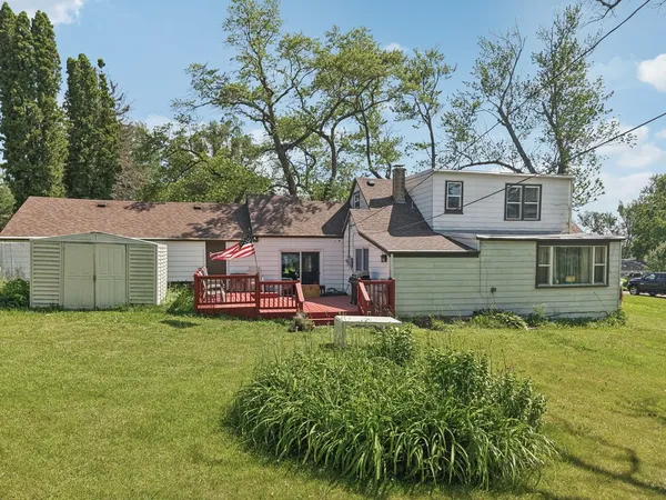a view of a house with a yard and large trees