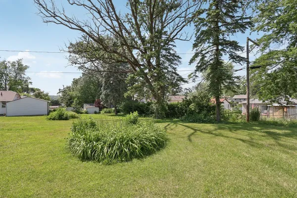 an aerial view of residential house with outdoor space and trees all around