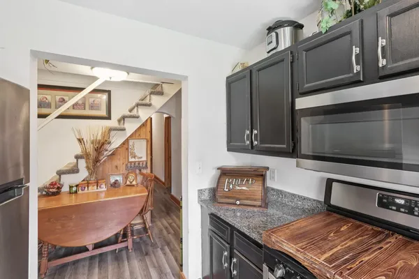 a kitchen with kitchen island granite countertop a sink stove and cabinets