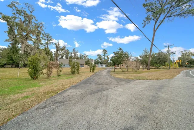 a view of a house with a tree and a yard