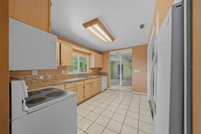 a kitchen with a stove a sink dishwasher and a refrigerator