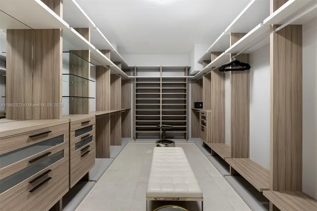 a view of walk in closet with clothes and shoes