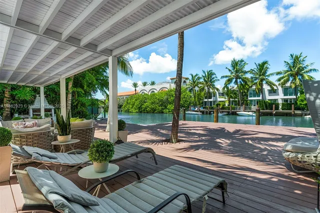 a view of a patio with table and chairs potted plants with wooden floor and fence