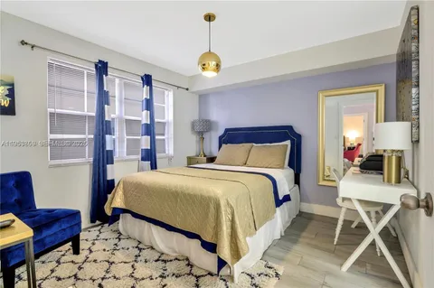 a bedroom with a bed a couch and potted plant