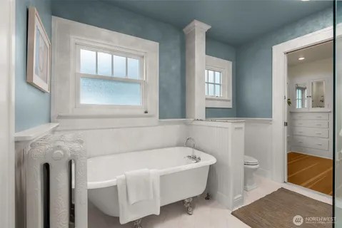 a bathroom with a tub sink and mirror