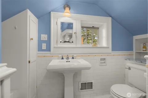 a bathroom with a sink mirror and toilet
