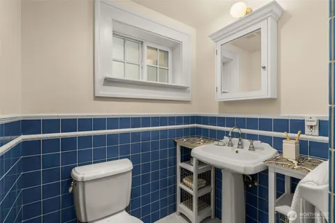 a bathroom with a sink a toilet and mirror
