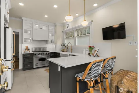 a kitchen with stainless steel appliances a stove a sink a microwave a refrigerator and cabinets