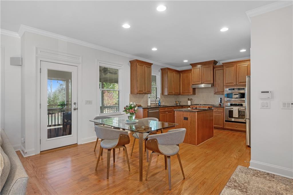 5740 Cascade Trail Cumming, GA 30040 - Photo 16 of 64 a kitchen with a table chairs refrigerator and cabinets