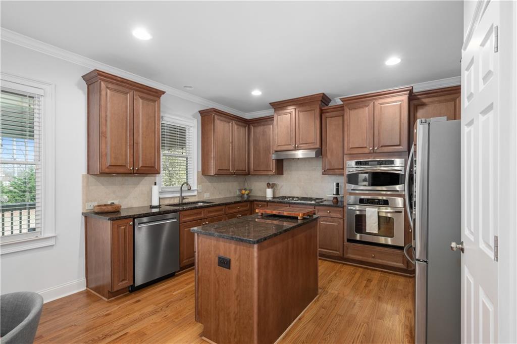 5740 Cascade Trail Cumming, GA 30040 - Photo 18 of 64 a kitchen with stainless steel appliances granite countertop a stove a sink dishwasher a refrigerator and a microwave oven with wooden floor