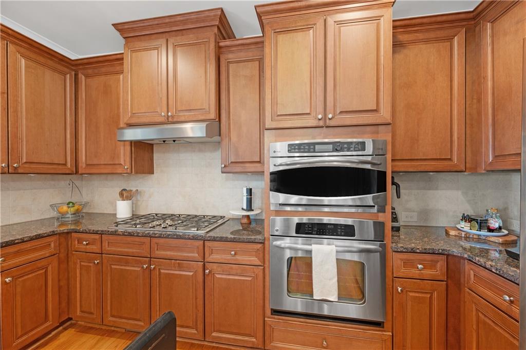 5740 Cascade Trail Cumming, GA 30040 - Photo 20 of 64 a kitchen with granite countertop a stove top oven microwave and cabinets