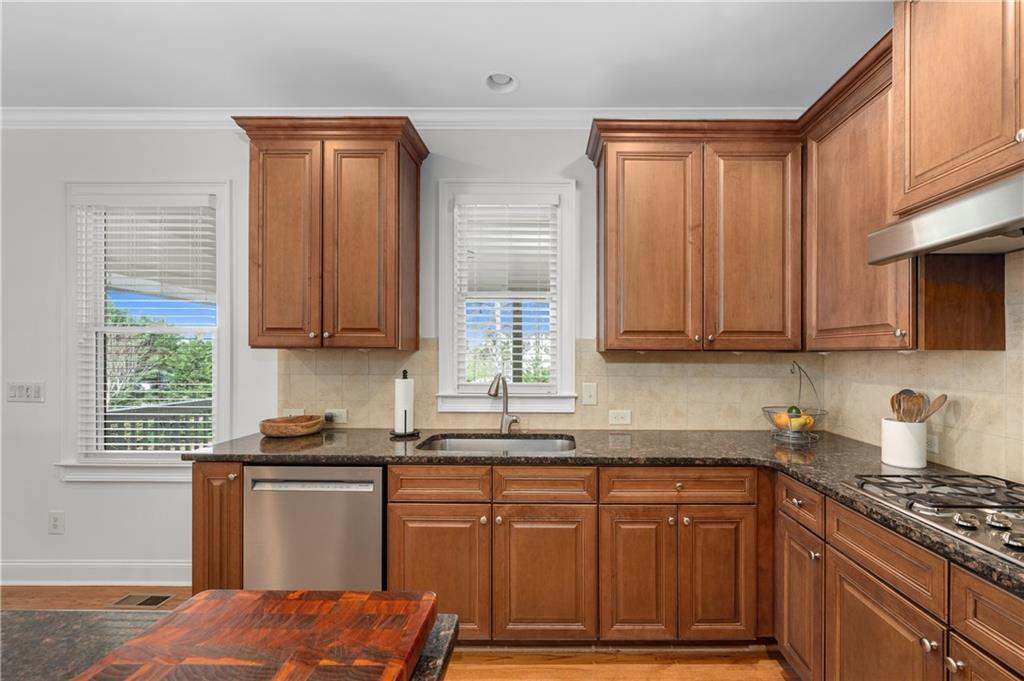 5740 Cascade Trail Cumming, GA 30040 - Photo 21 of 64 a kitchen with stainless steel appliances granite countertop a stove a sink dishwasher and cabinets with wooden floor
