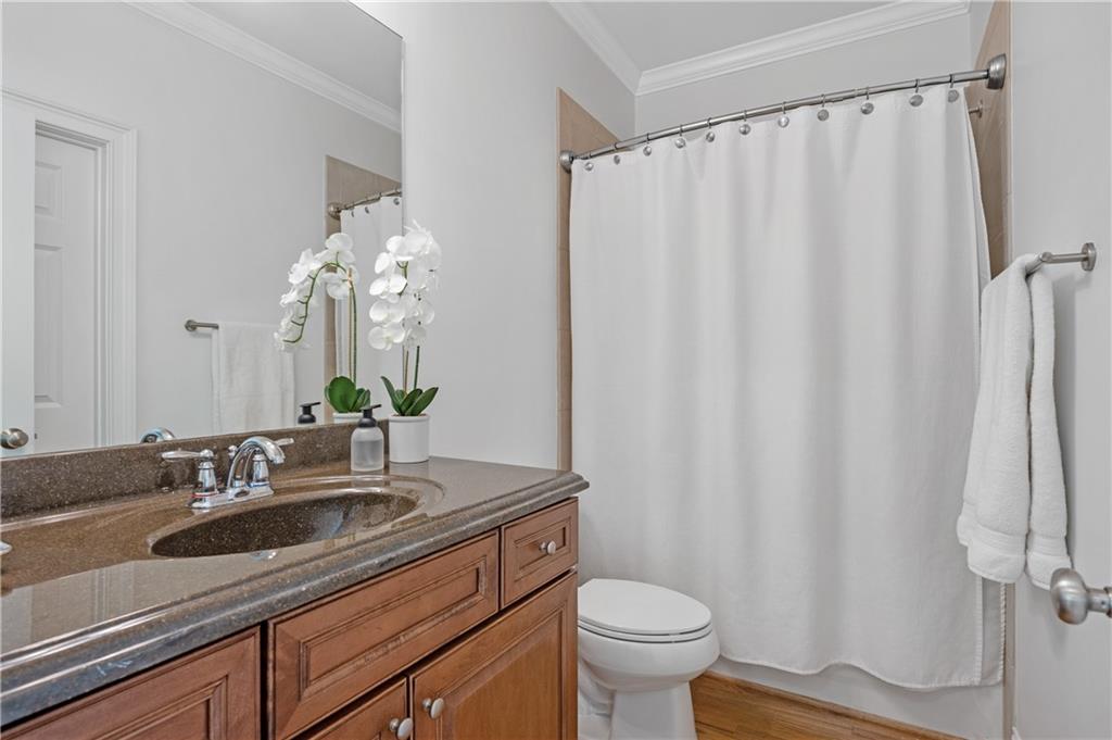 5740 Cascade Trail Cumming, GA 30040 - Photo 22 of 64 a bathroom with a sink a toilet and shower curtain