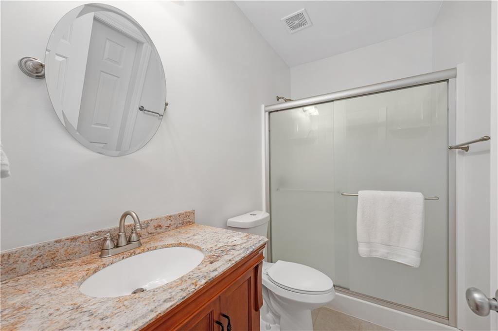5740 Cascade Trail Cumming, GA 30040 - Photo 38 of 64 a bathroom with a granite countertop sink a toilet and a mirror