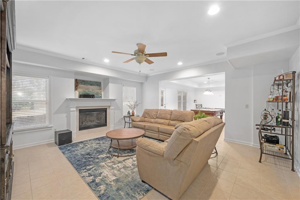 5740 Cascade Trail Cumming, GA 30040 - Photo 40 of 64 a living room with furniture a fireplace and a flat screen tv