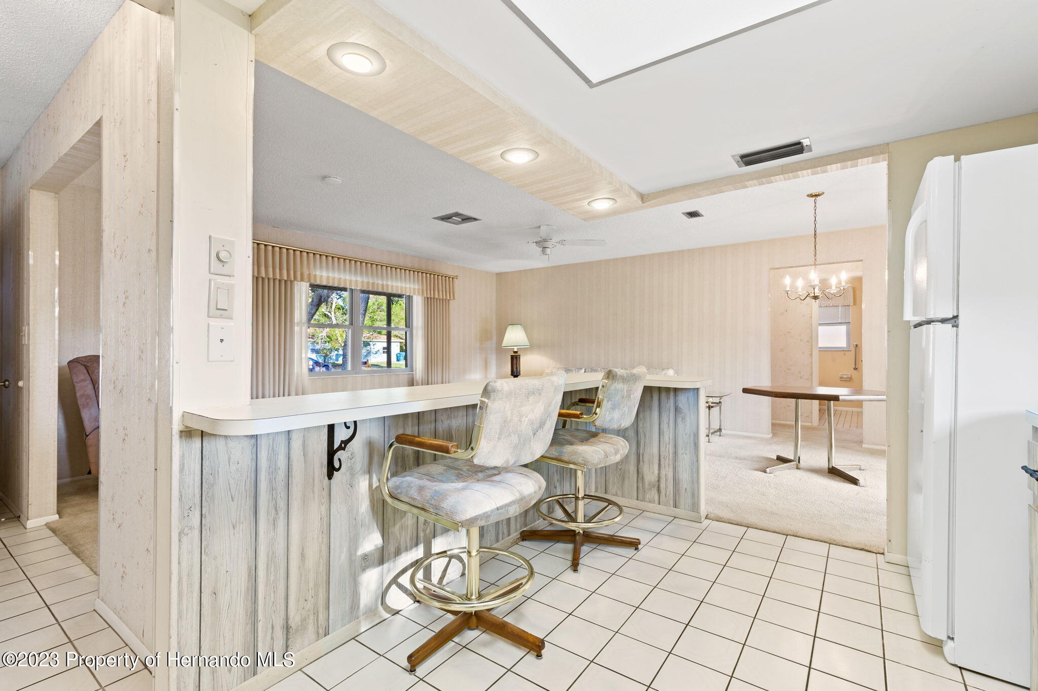 129 Candlewick Avenue Spring Hill, FL 34608 - Photo 11 of 28 15 kitchen with bar stools facing living