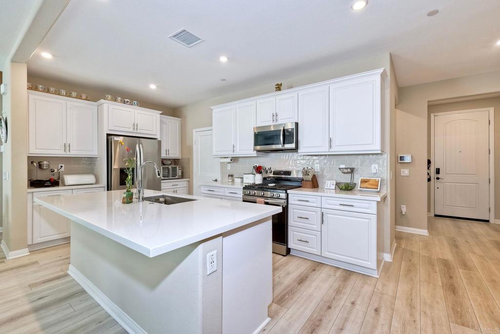 a kitchen with a sink a counter top space stainless steel appliances and cabinets