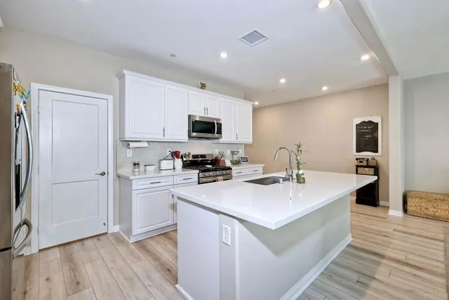 a kitchen with white cabinets and stainless steel appliances