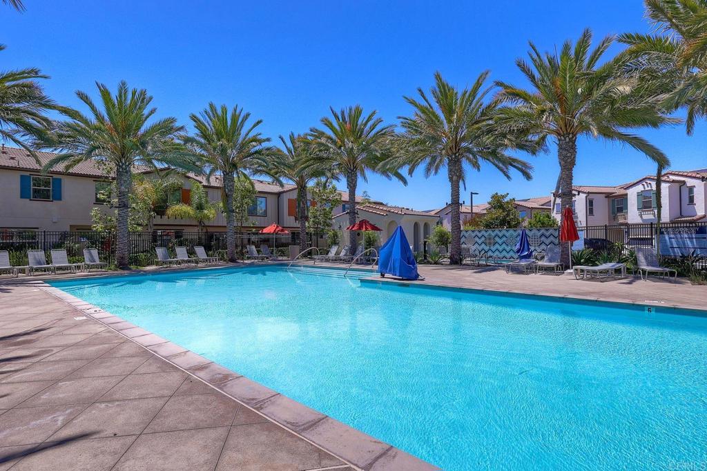 1715 Crabapple Way Oceanside, CA 92056 - Photo 26 of 31 a view of a swimming pool with a table and chairs under palm trees