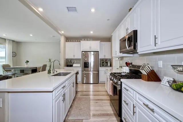 a kitchen with a sink a stove top oven and refrigerator