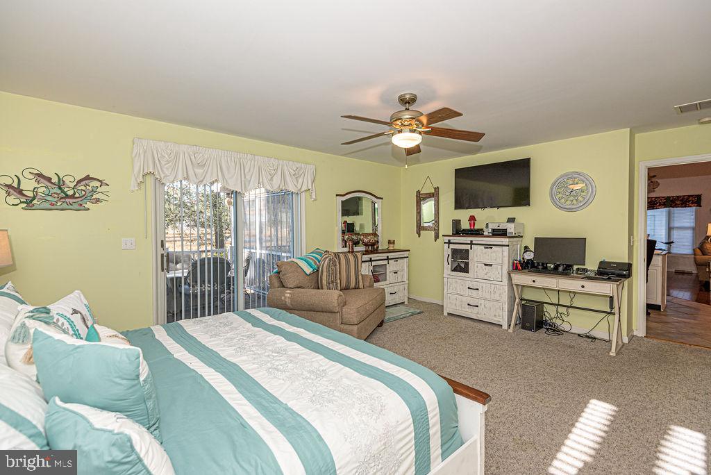 19 Mist Flower Road Ocean Pines, MD 21811 - Photo 16 of 36 a bedroom with a bed a chandelier and a flat screen tv