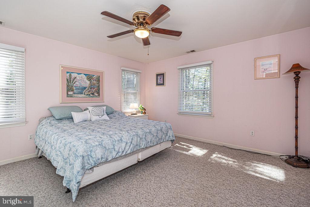19 Mist Flower Road Ocean Pines, MD 21811 - Photo 24 of 36 a spacious bedroom with a bed a window and a chandelier
