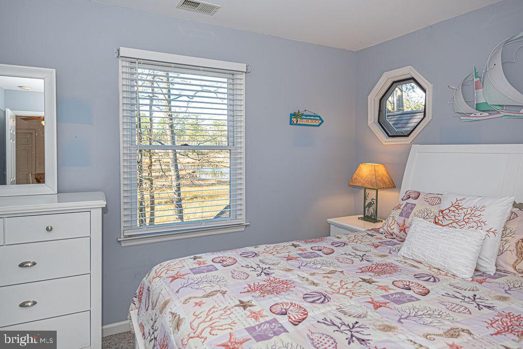 19 Mist Flower Road Ocean Pines, MD 21811 - Photo 29 of 36 a bedroom with a bed and a lamp on dresser next to a window