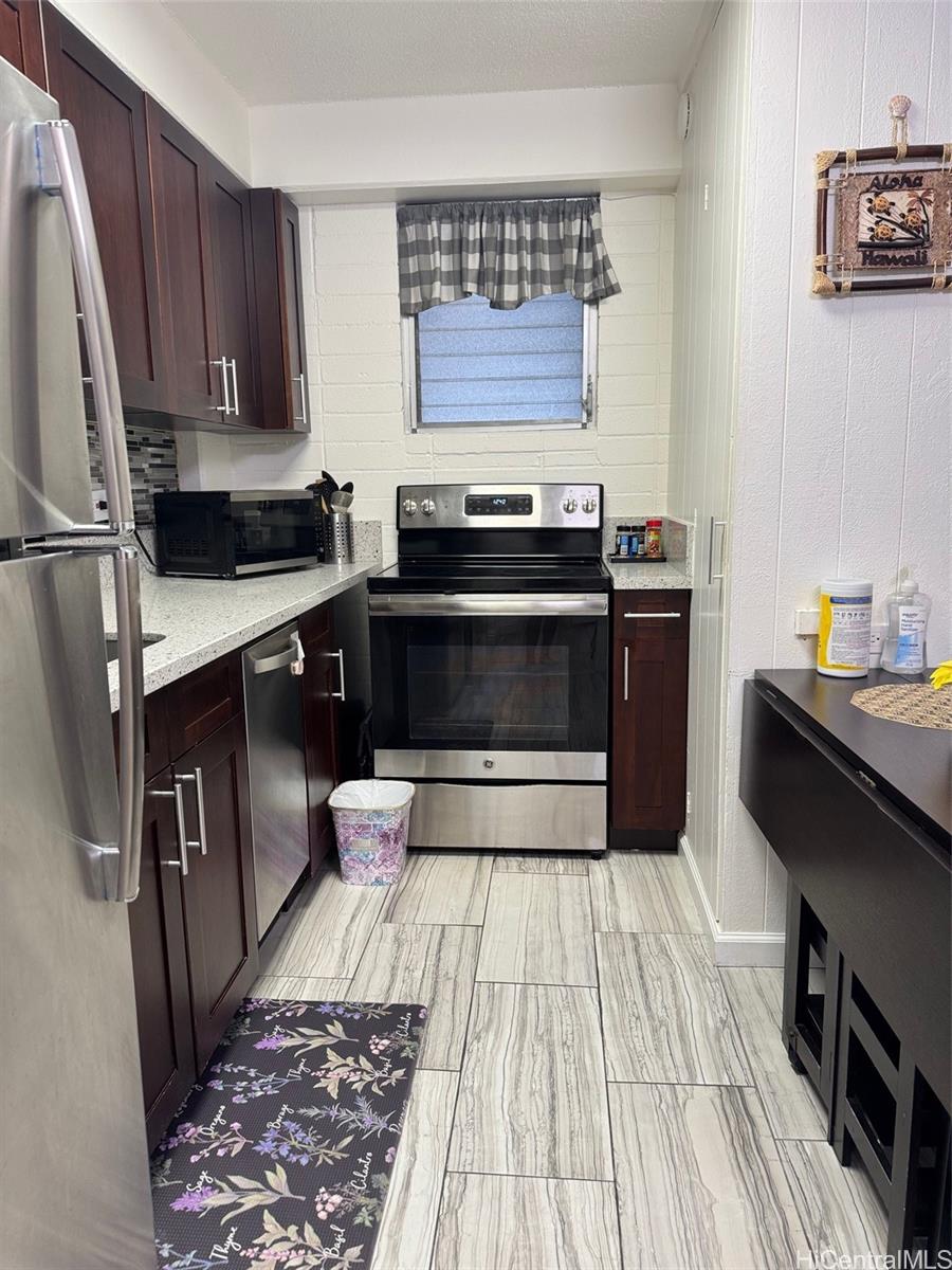 417 Nohonani Street, Unit 410 Honolulu, HI 96815 - Photo 4 of 20 a kitchen with granite countertop a stove a sink and a refrigerator