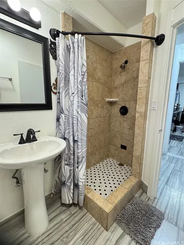 a bathroom with a sink a toilet and shower