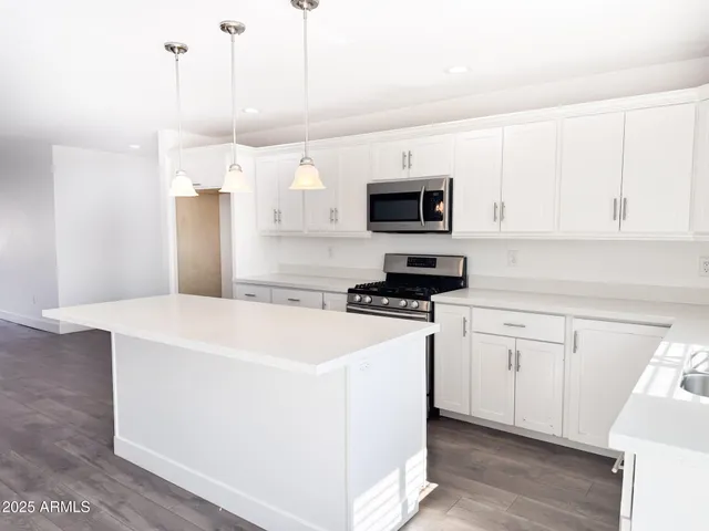 a kitchen with stainless steel appliances granite countertop a sink a stove a microwave and a refrigerator