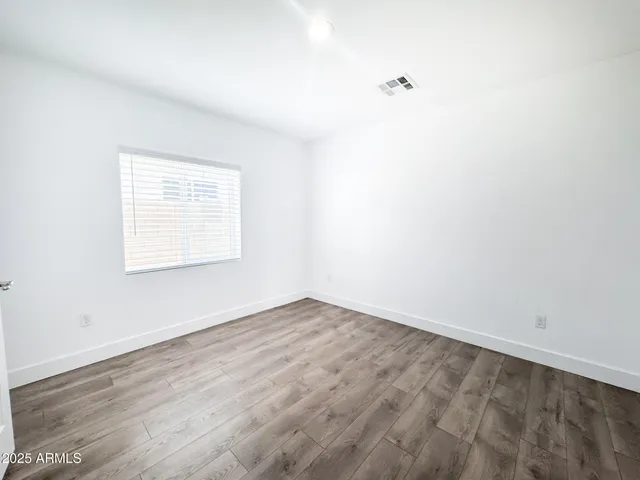a large kitchen with cabinets wooden floor and stainless steel appliances