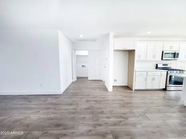 a view of empty room with wooden floor