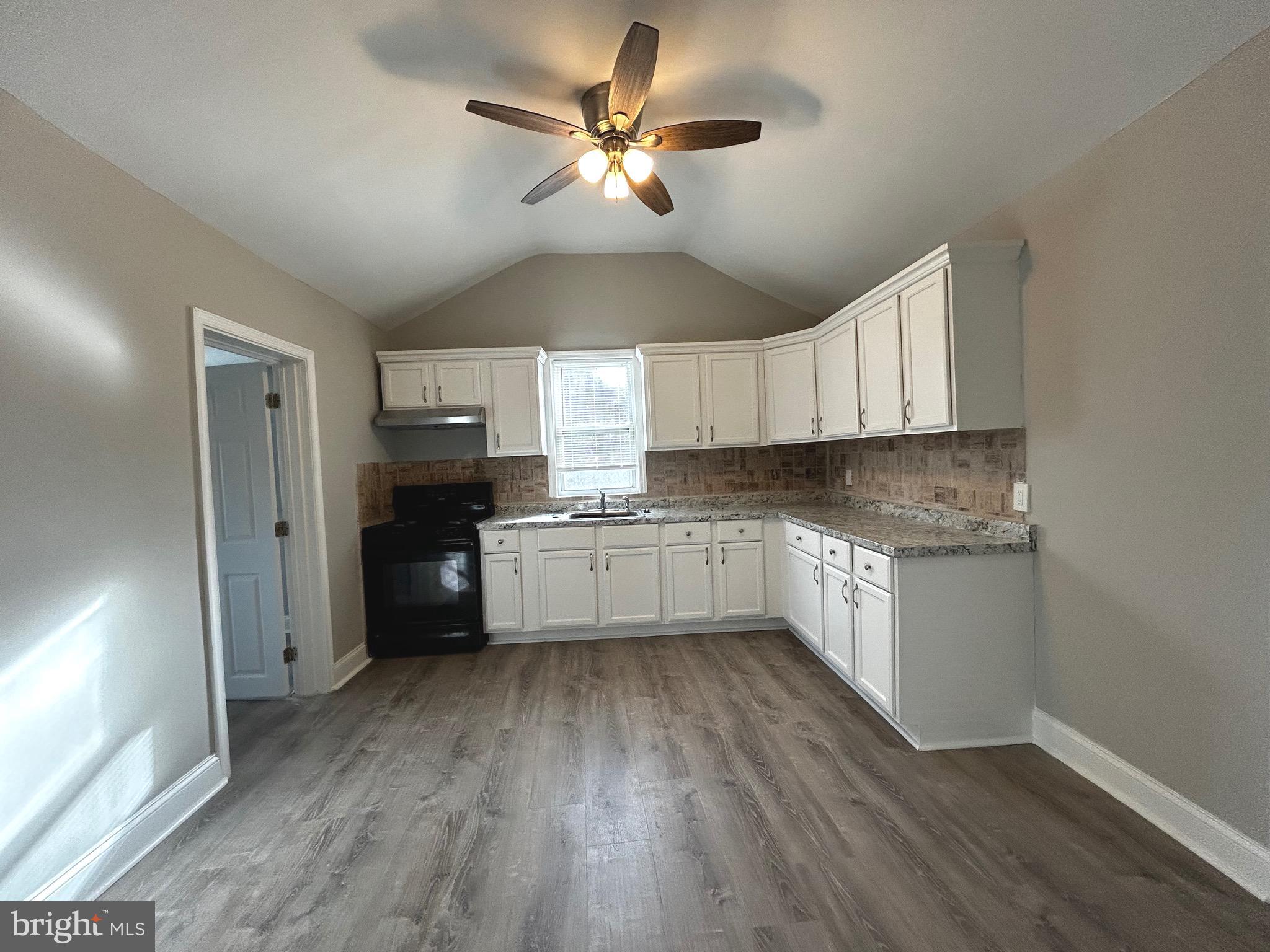 448 Plum Alley Spring City, PA 19475 - Photo 9 of 15 a kitchen with granite countertop a refrigerator a sink dishwasher a stove and white cabinets with wooden floor