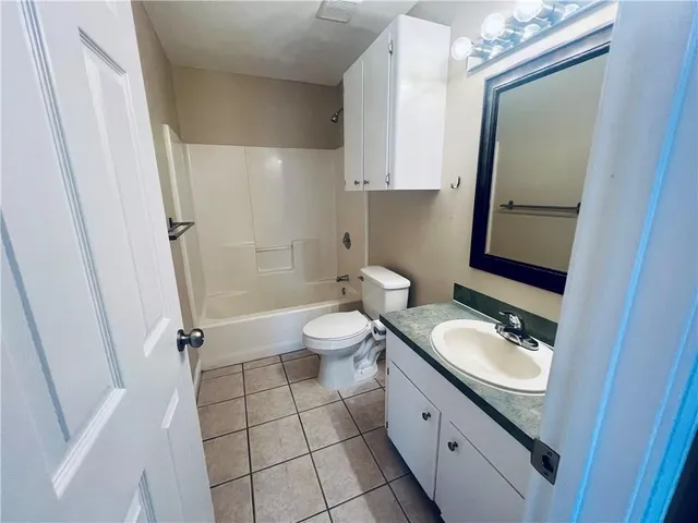 a bathroom with a granite countertop toilet sink and mirror