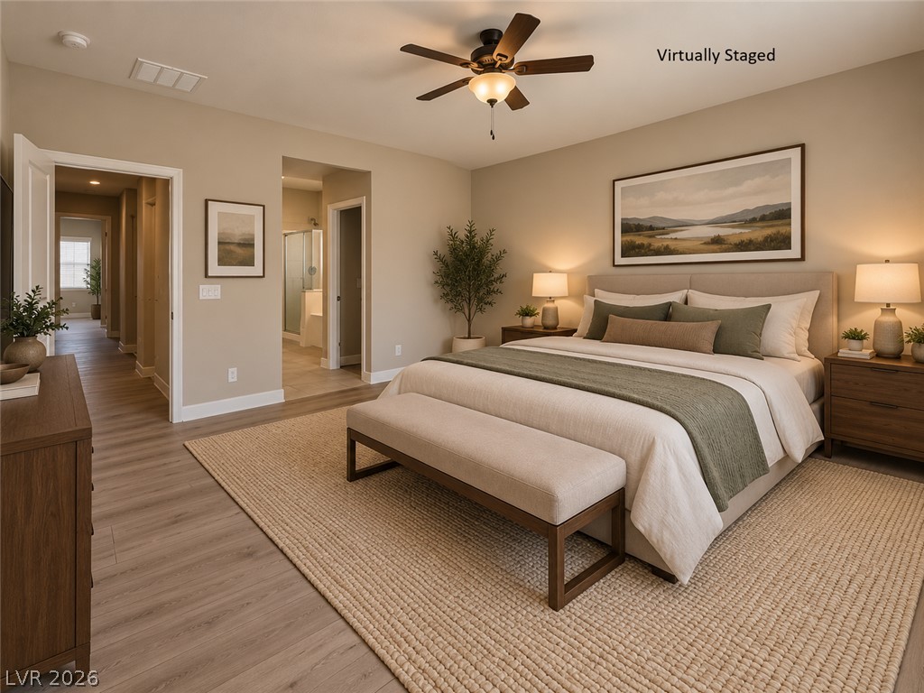 8059 Encanterra Road Las Vegas, NV 89113 - Photo 28 of 52 Warm wood-style flooring runs throughout this bedroom suite leading to an attached bathroom.