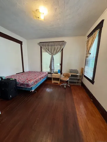 a bedroom with two beds and wooden floor