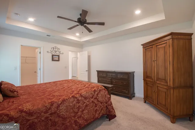 a spacious bedroom with a bed and a ceiling fan