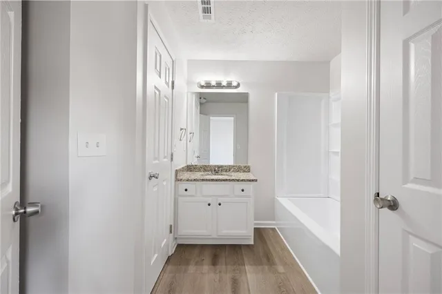 a bathroom with a tub sink and mirror