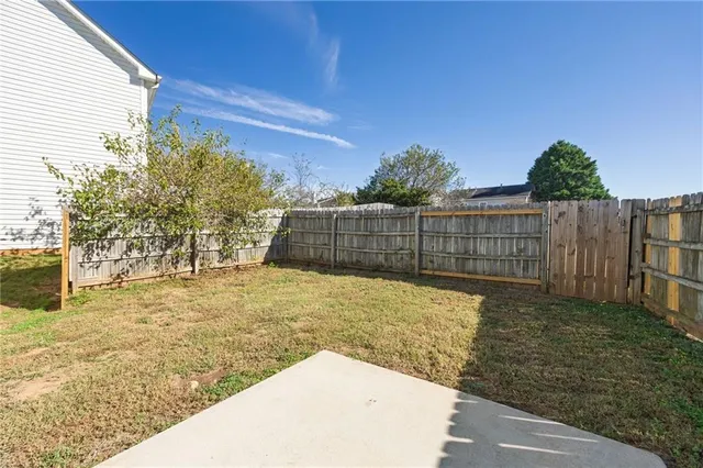 a view of backyard with wooden fence