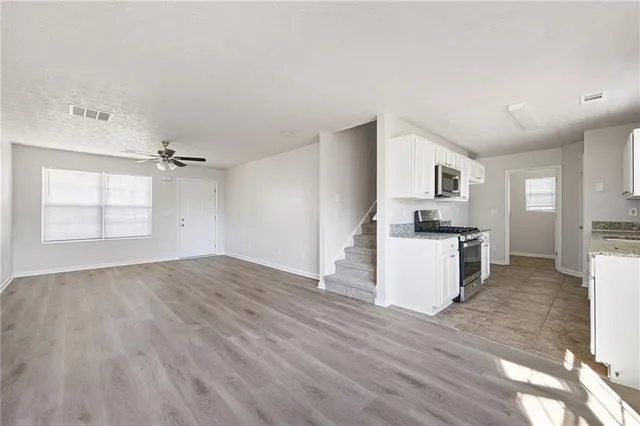 a view of kitchen with sink microwave and cabinets