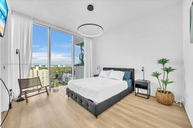 a bedroom with a large bed and a potted plant