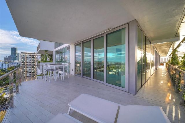 a dining room with furniture and a floor to ceiling window
