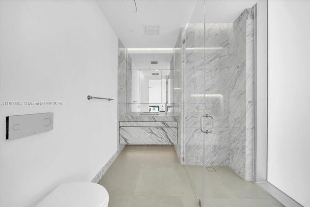 a bathroom with a granite countertop sink mirror and toilet