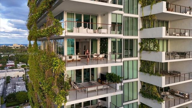 a front view of a building with a garden and plants
